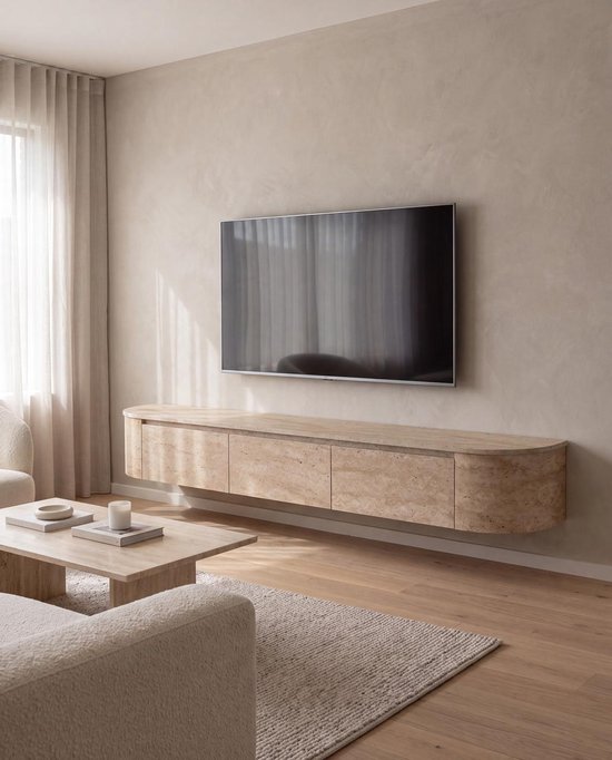 Zwevend Japandi tv-meubel van travertin met gebogen zijkant en vier gesloten deuren. Het meubel heeft een natuurlijke beige kleur met zichtbare aders.