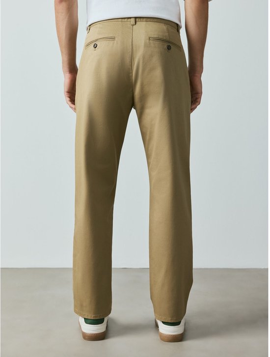 Zijaanzicht man met zandkleurige chino en blauwe hoodie