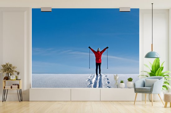 Papier peint photo vinyle - Un skieur marche avec ses bâtons de ski au sommet de la montagne largeur 350 cm x hauteur 260 cm - Tirage photo sur papier peint (disponible en 7 tailles)