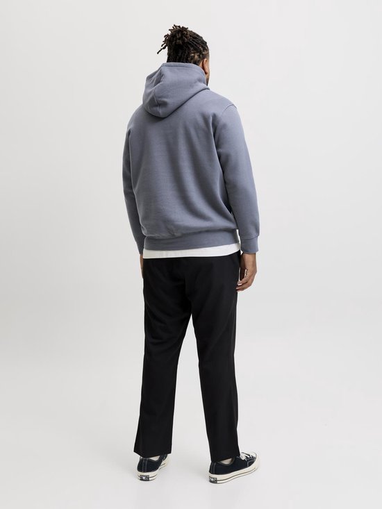 Man, van achteren gezien, draagt een grijze hoodie met capuchon en zwarte broek.