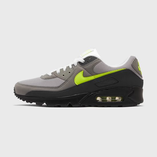 Zijenaanzicht van een grijze Nike Air Max 90 sneaker met neon groene Nike 'swoosh' en zwarte zool.