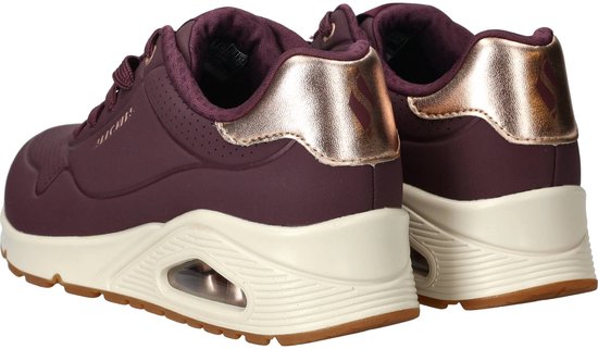 Achterkant van paarse Skechers sneakers met beige zool en gouden hielaccent.