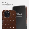 Dichtbij een bruin telefoonhoesje met witte stippen en een telefoon met verhoogde randen.