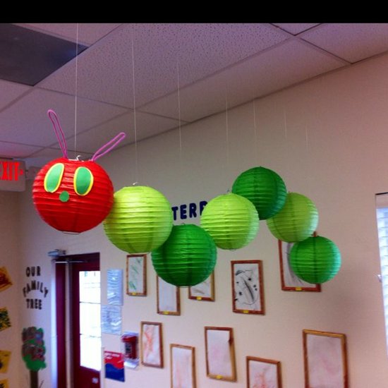 Een decoratie van een rups gemaakt van een rode lampion met groene en roze details, gevolgd door groene lampionnen.