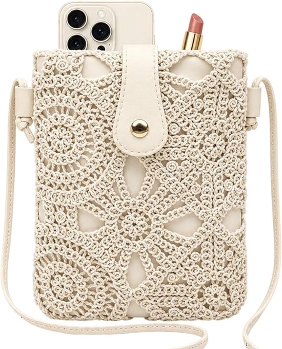 Crèmekleurige gehaakte tas met beige riem, telefoon en lippenstift in de bovenkant.