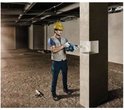Man met gele helm boort in betonpaal met blauwe Bosch boor.