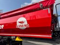 Rode aanhanger met witte cirkel met veer-logo en tekst '5.850 KG'.