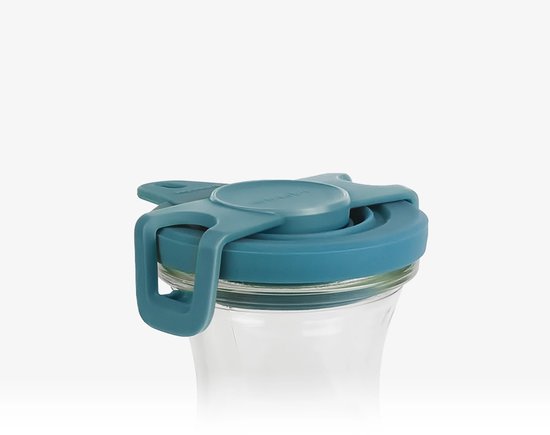 Gedetailleerde opname van een turquoise deksel met lipjes, op een glazen karaf.