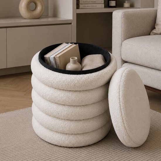 Pouf de rangement blanc en tissu teddy avec intérieur noir, rempli de livres et d'un vase.