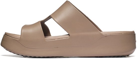 Zij-aanzicht van een bruine Crocs slipper met open zijkanten en een dikke plateauzool.