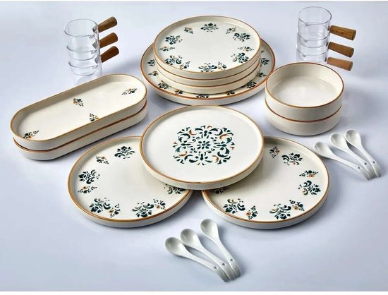 Wit servies met oranje rand en groen-bruin bloemenpatroon. Schalen, borden, glazen en lepels met houten handvat.
