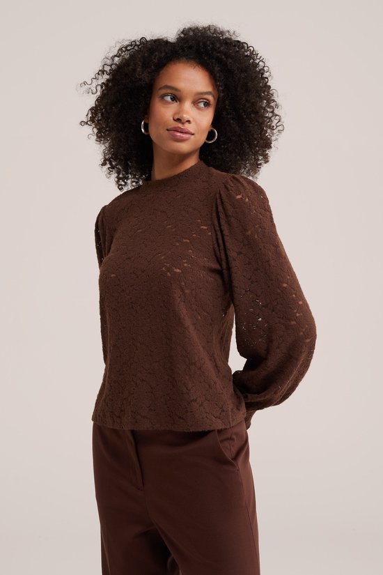 Model van voren, staand in bruine kanten top met pofmouwen en bruine broek.