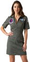 Vrouw met bruine haren draagt groene pilotenjurk met 'Top Gun' en vliegdekschip patches.