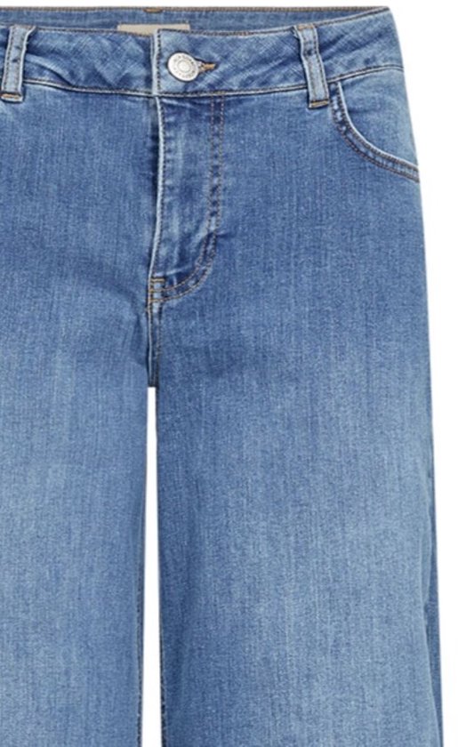 Detailopname van de taille en de zilverkleurige knoop van een lichtblauwe jeans.