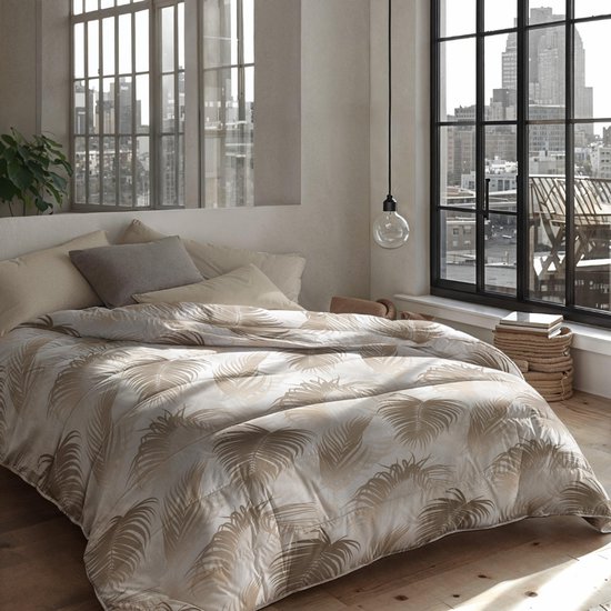 Dekbed met een beige palmbladerenprint op een crèmekleurige achtergrond, opgemaakt op een bed met uitzicht op een stad.