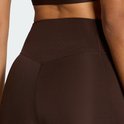 Close-up van de tailleband van een donkerbruine legging met stiksels.