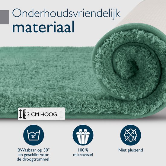 Rol van een groene badmat die 3 cm hoog is. Het materiaal is onderhoudsvriendelijk, 100% microvezel en niet pluizend.
