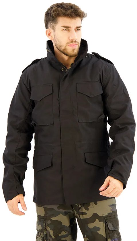 Zwarte herenjas met hoge kraag, epauletten en vier klepzakken. Gedragen met camouflage cargo broek.