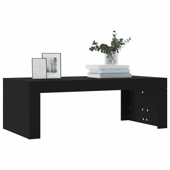 Zwarte salontafel van bewerkt hout, 102x50x36 cm, met decoratieve fotolijsten en een vaas met planten.