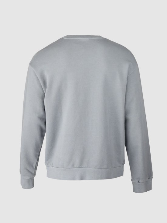 Achterkant van een man in een lichtblauwe trui met lange mouwen en lichtblauwe jeans.