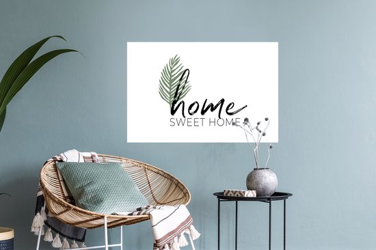 Witte muursticker met zwarte 'home' tekst, 'SWEET HOME' in drukletters en een groen palmblad.