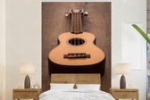 Behang - Fotobehang Akoestische gitaar op een houten tafel - Breedte 225 cm x hoogte 350 cm