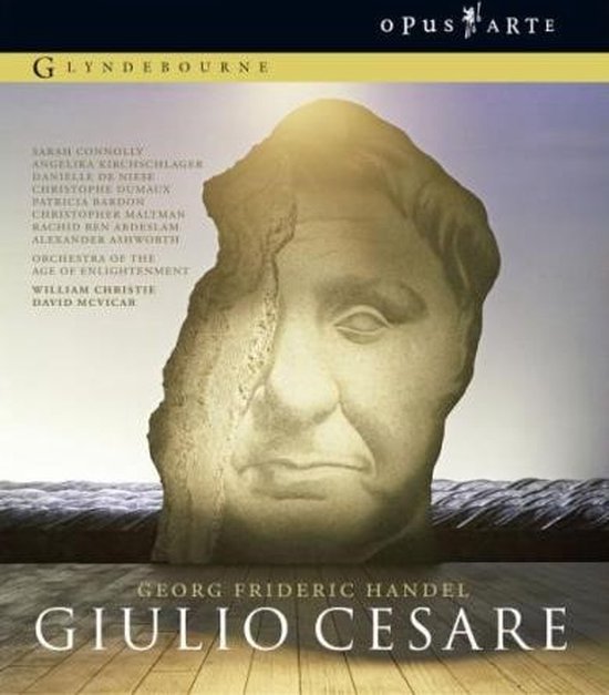 Gegraveerd buste van Giulio Cesare op een stenen fragment, met de titel van de opera en cast. Blu-ray hoes.