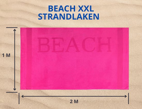 Een felroze XXL strandlaken van 1x2 meter met de tekst 'BEACH' in reliëf, liggend op zand.