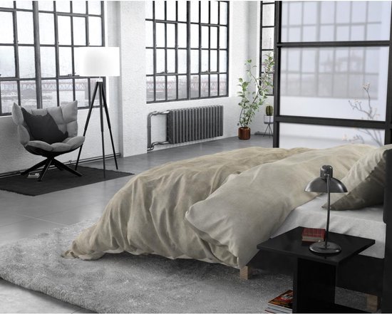 Sleeptime dekbedovertrek in taupe in een modern interieur met grote ramen en een grijze fauteuil.
