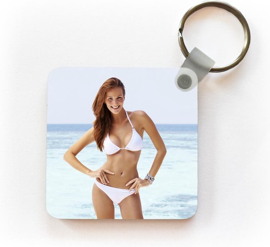 Kleverig Ook spleet Sleutelhanger - Een jonge vrouw met een witte bikini poseert voor de camera  - Plastic | bol.com