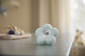 Lichtgroene Philips Avent bloemvormige thermometer op een tafel. Toont 18.0°C.