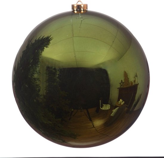 Boule de Noël vert foncé brillante en plastique avec un capuchon doré. La boule reflète un sapin de Noël.