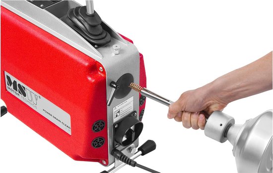 Hand houdt de spiraal van de rode pijpenreinigingsmachine, met metalen spiraal en een grijze houder.
