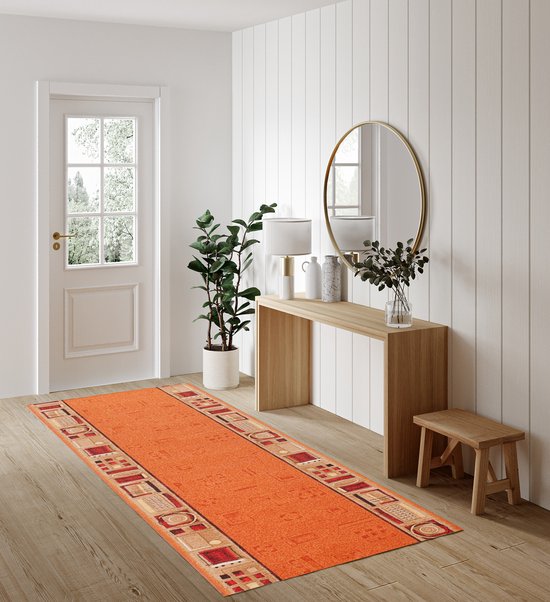 Tapis orange avec des bordures géométriques beiges et rouges, dans un couloir avec une console.