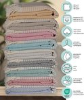 Stapel handdoeken in verschillende kleuren, met strepen en patronen. Gemaakt van 100% katoen.