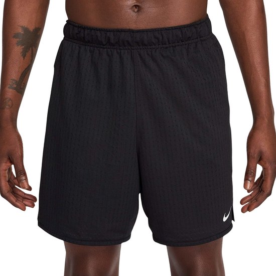 Man in zwarte Nike sportbroek, met witte swoosh op linkerpijp.