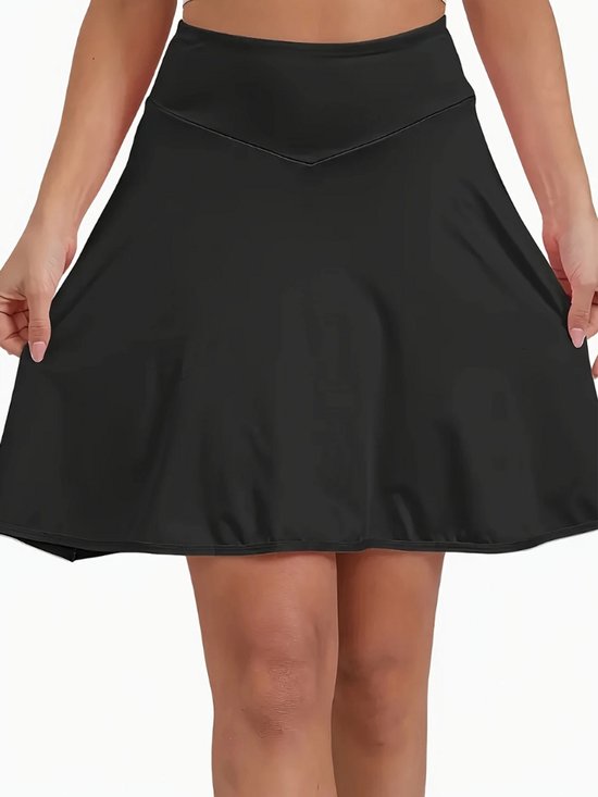 Zwarte skort, de voorkant wordt door het model omhoog gehouden.