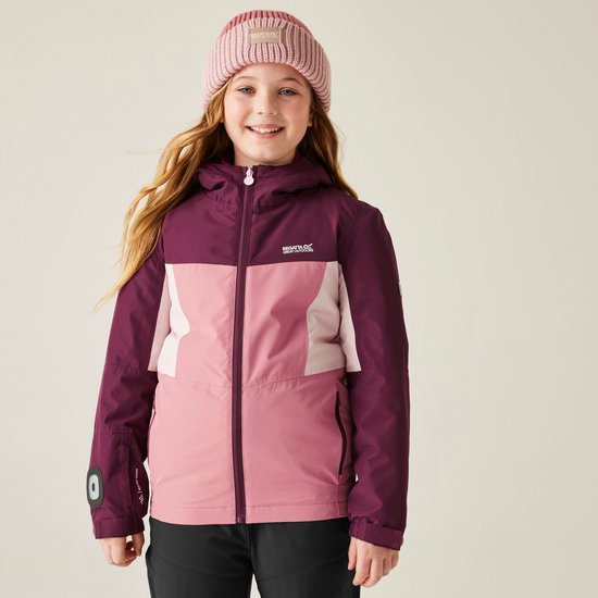 Meisje in bordeauxrode, roze en lichtroze jas met capuchon, roze muts en zwarte broek.