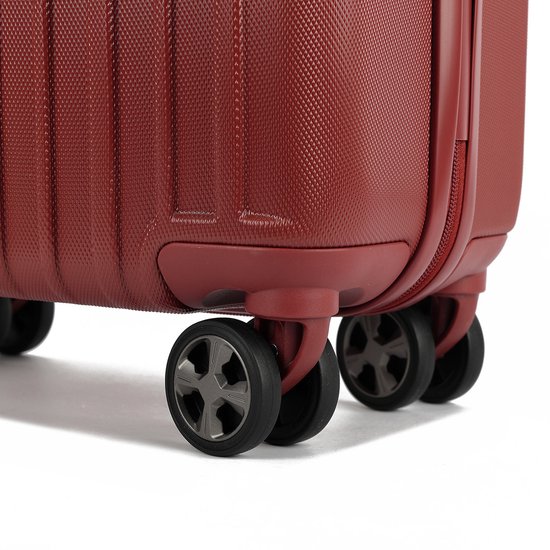 Bas d'une valise rouge avec quatre roues noires.