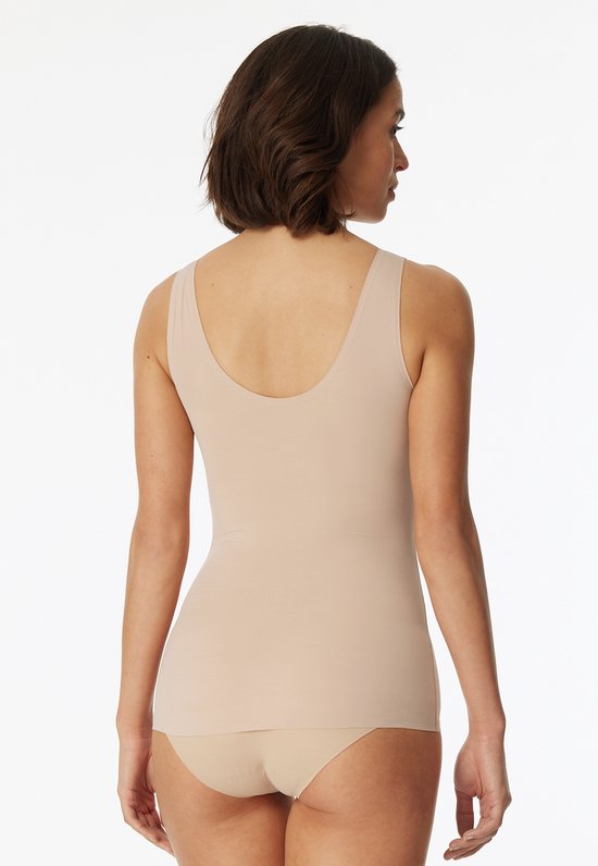 Achterkant van een nude shapewear top met V-hals, gedragen door een model.