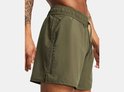 Legergroene shorts met verticale zwarte Under Armour-letters op de linkerpijp