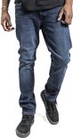 De voorkant van een man in een donkerblauwe jeans, met zwarte Vans schoenen.