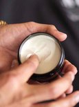 Handen die American Crew Matte Clay uit een pot halen
