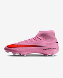 Roze Nike voetbalschoen met rode swoosh, AIR ZOOM tekst en lichtblauwe noppen.