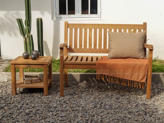 Houten tuinbank met rugleuning en armleuningen, met een beige kussen en oranje plaid met franjes.