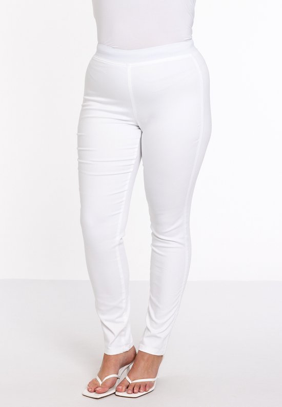 Model van voren gezien in een strakke, witte broek met hoge taille. Ze draagt witte sandalen.