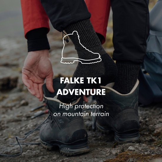 Man trekt donkergrijze wandelsokken aan met een leren wandelschoen. Tekst: FALKE TK1 ADVENTURE.