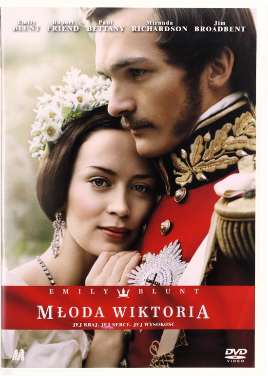 Emily Blunt als jonge koningin Victoria met bloemen in haar haar, naast een man in een rood militair uniform.