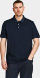 Donkerblauw poloshirt met korte mouwen en knoopjes, gedragen door een man met een hand in zijn zak.