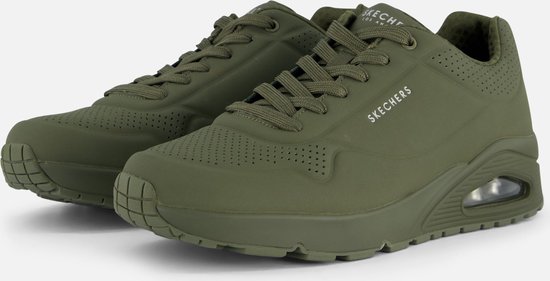 Deux sneakers Skechers vertes alignées, gros plan sur les lacets et le côté.